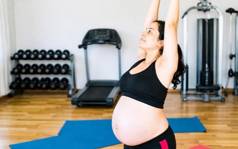 Gestante realizando exercício físico com segurança e orientação profissional